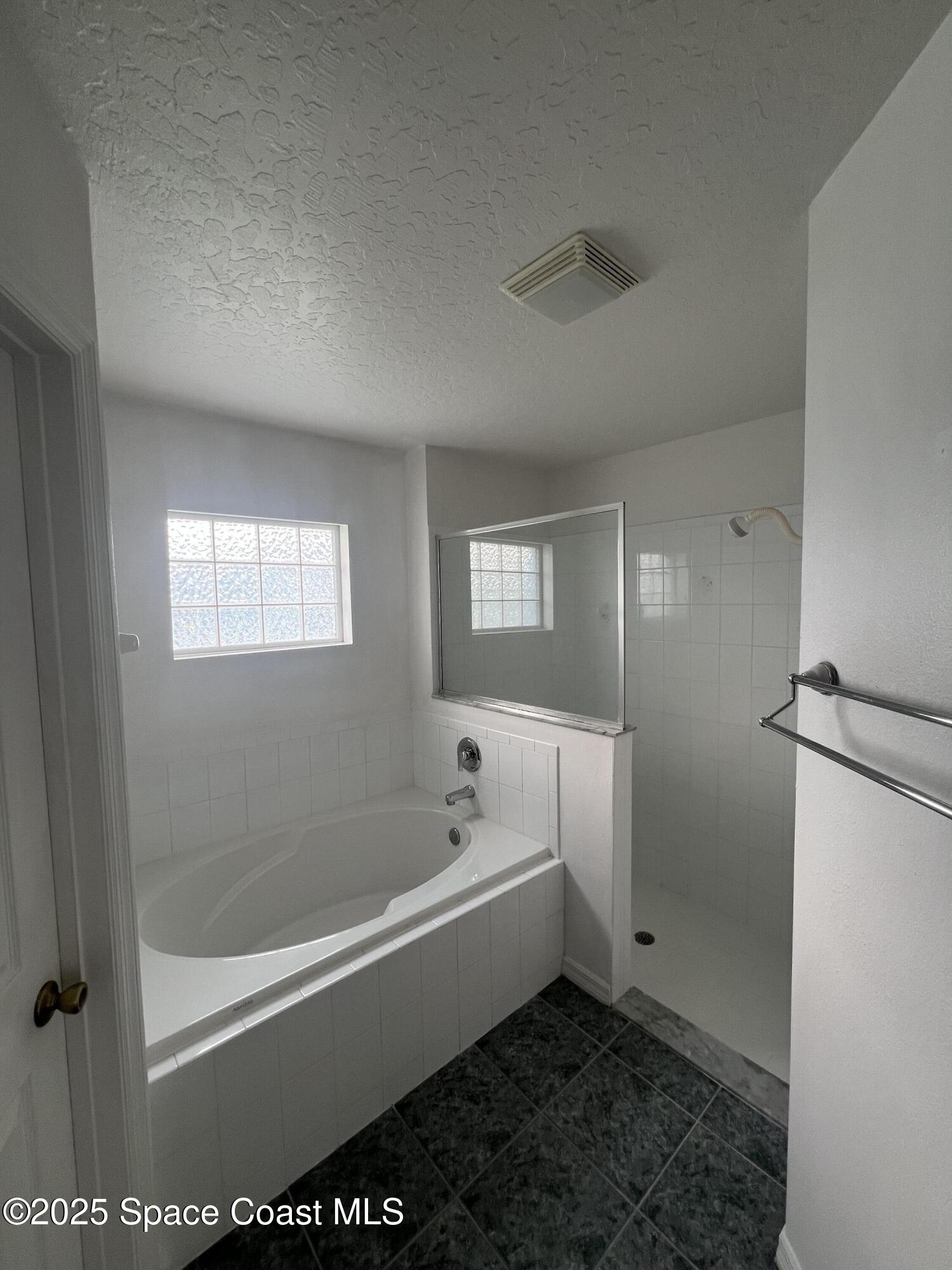 1213 Old Millpond Road Melbourne, FL 32940 - Photo 13 of 20 a bathroom with a bathtub a toilet and a shower