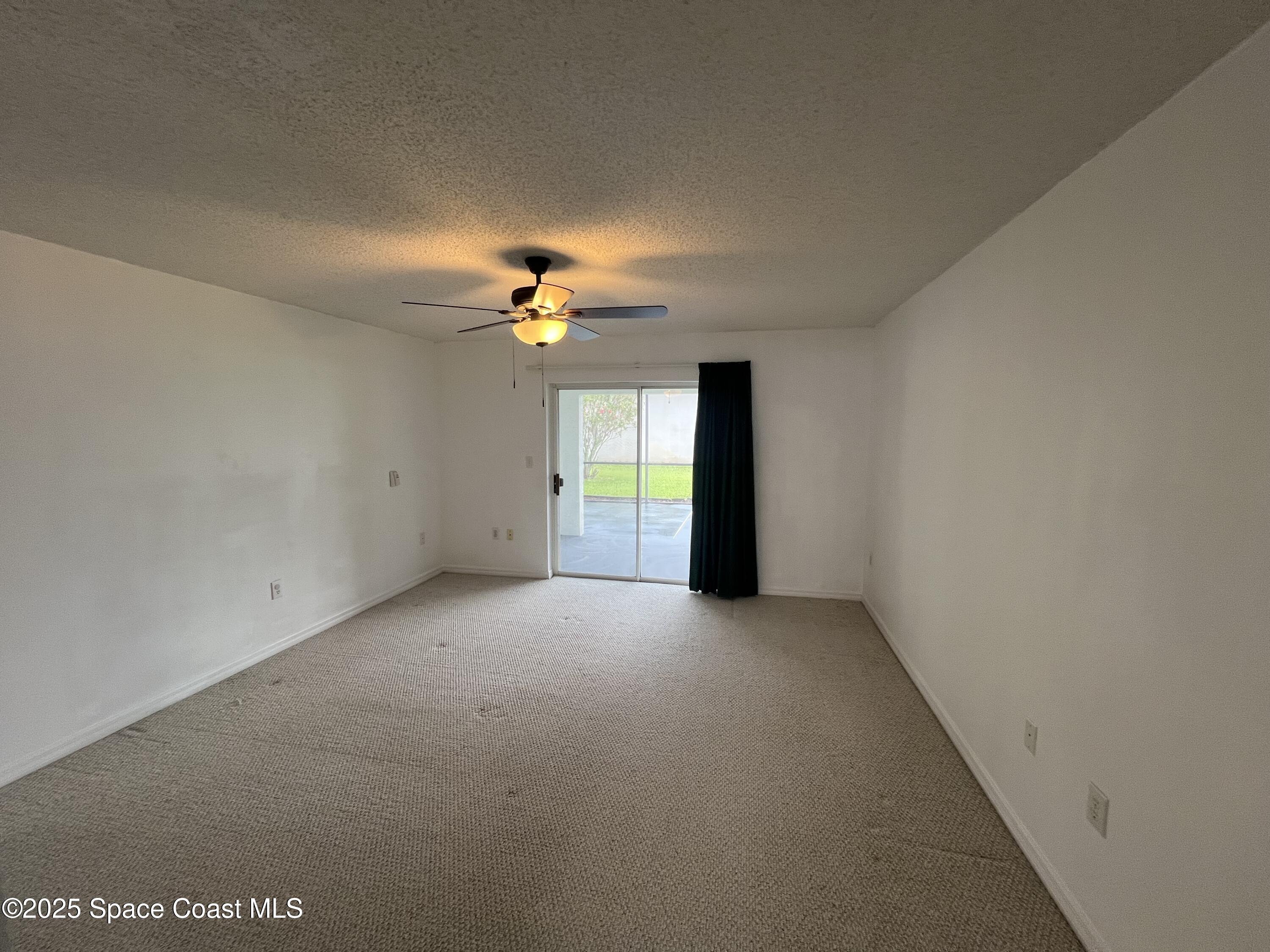 1213 Old Millpond Road Melbourne, FL 32940 - Photo 10 of 20 a view of an empty room with a chandelier fan