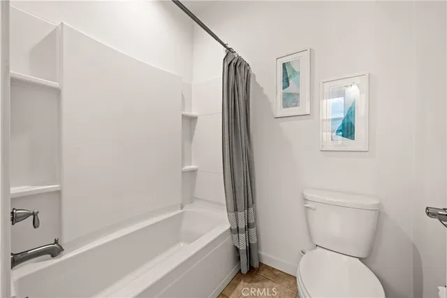 a white toilet sitting next to a bath tub