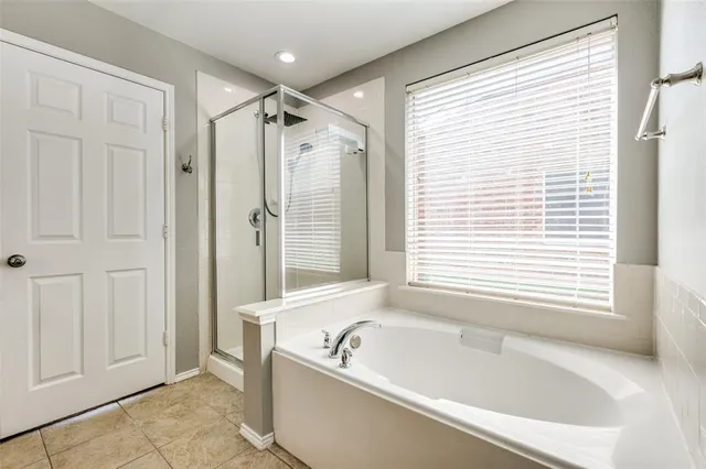 a bathroom with a tub a shower and a sink
