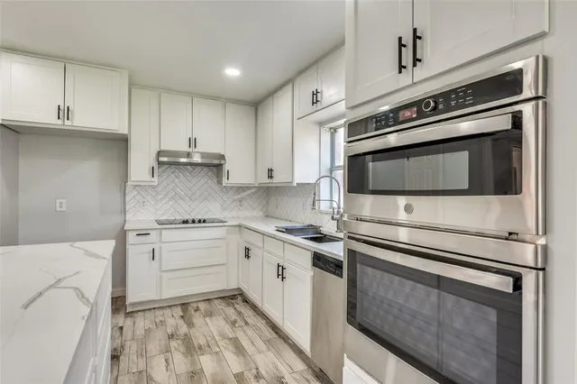 a kitchen with granite countertop cabinets stainless steel appliances and a sink