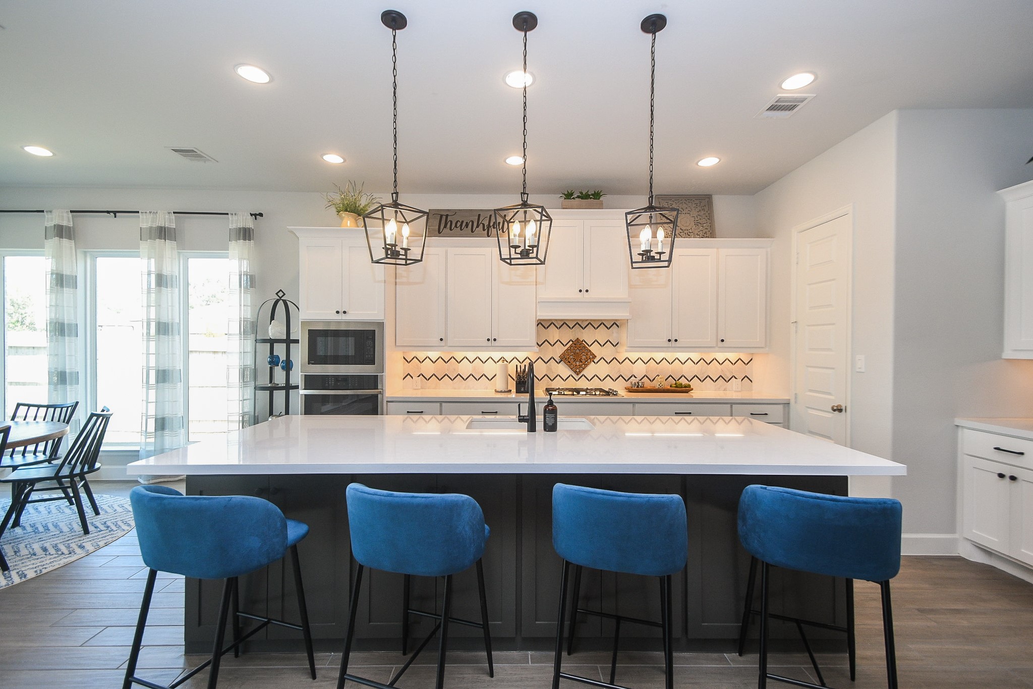 30314 Brook Point Fulshear, TX 77441 - Photo 9 of 38 Modern flair kitchen with stone countertops and ample seating at the oversized island, which offers storage on both sides.