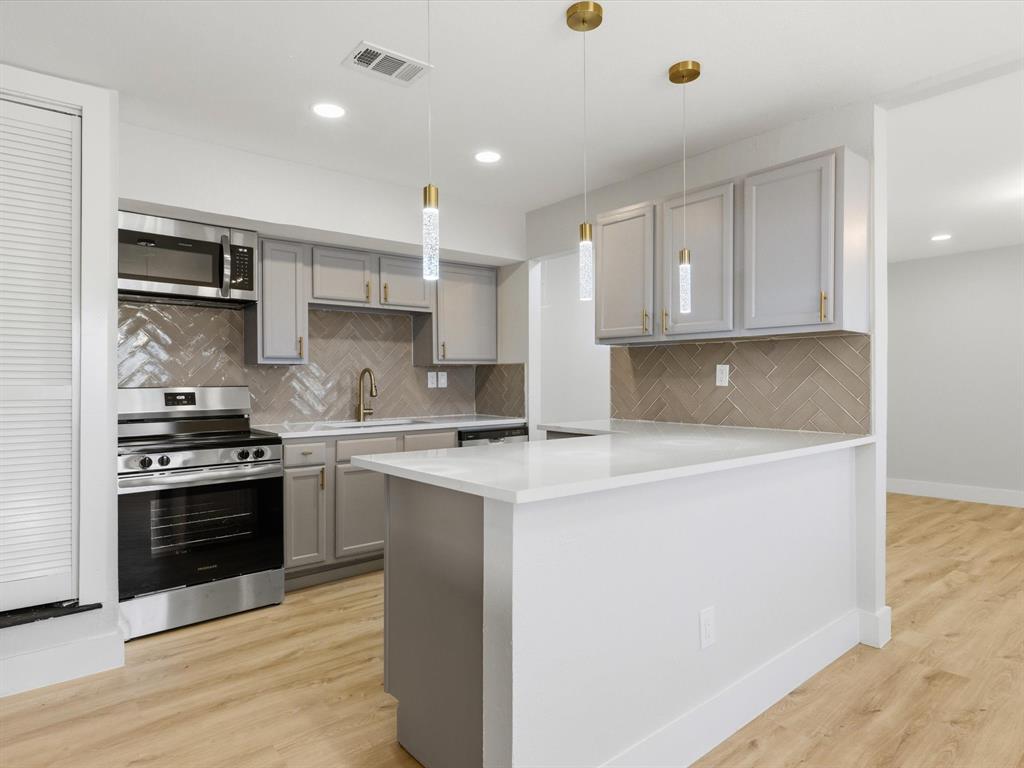 4013 Oleander Trail Mesquite, TX 75150 - Photo 7 of 28 Kitchen with gray cabinets, appliances with stainless steel finishes, light wood finished floors, and recessed lighting