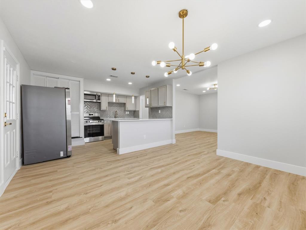 4013 Oleander Trail Mesquite, TX 75150 - Photo 28 of 28 Kitchen featuring appliances with stainless steel finishes, open floor plan, backsplash, a chandelier, and light countertops