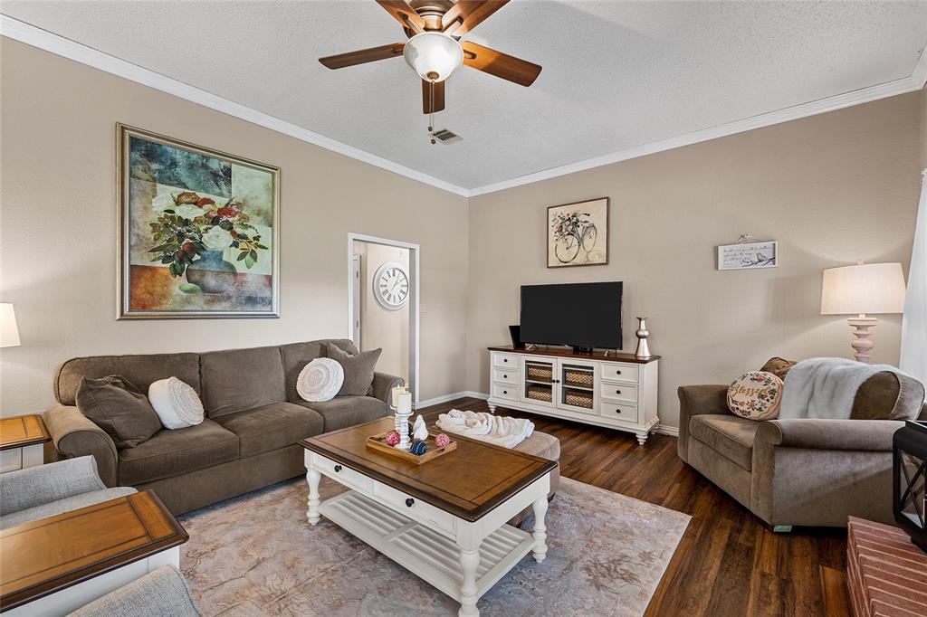 4617 Lexington Street Waco, TX 76705 - Photo 3 of 14 Living area featuring wood-finish flooring, a ceiling fan with light fixture, and crown molding
