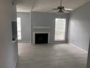 an empty room with windows and fireplace
