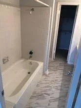 a bathroom with a tub shower and a sink