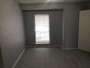 3645 West Northgate Drive, Unit 202 Irving, TX 75062 - Photo 9 of 12 an empty room with wooden floor and windows