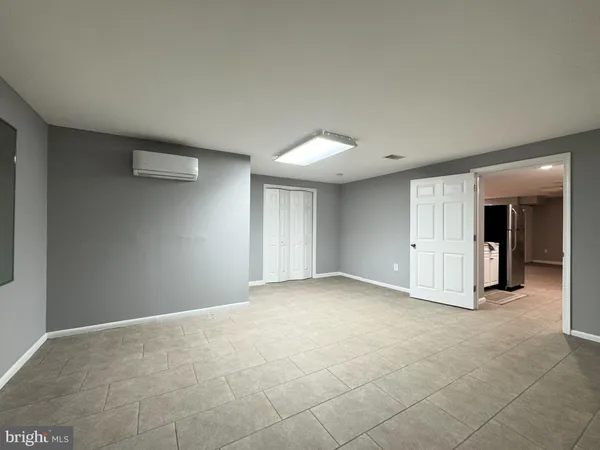 a view of an empty room with closet and a window