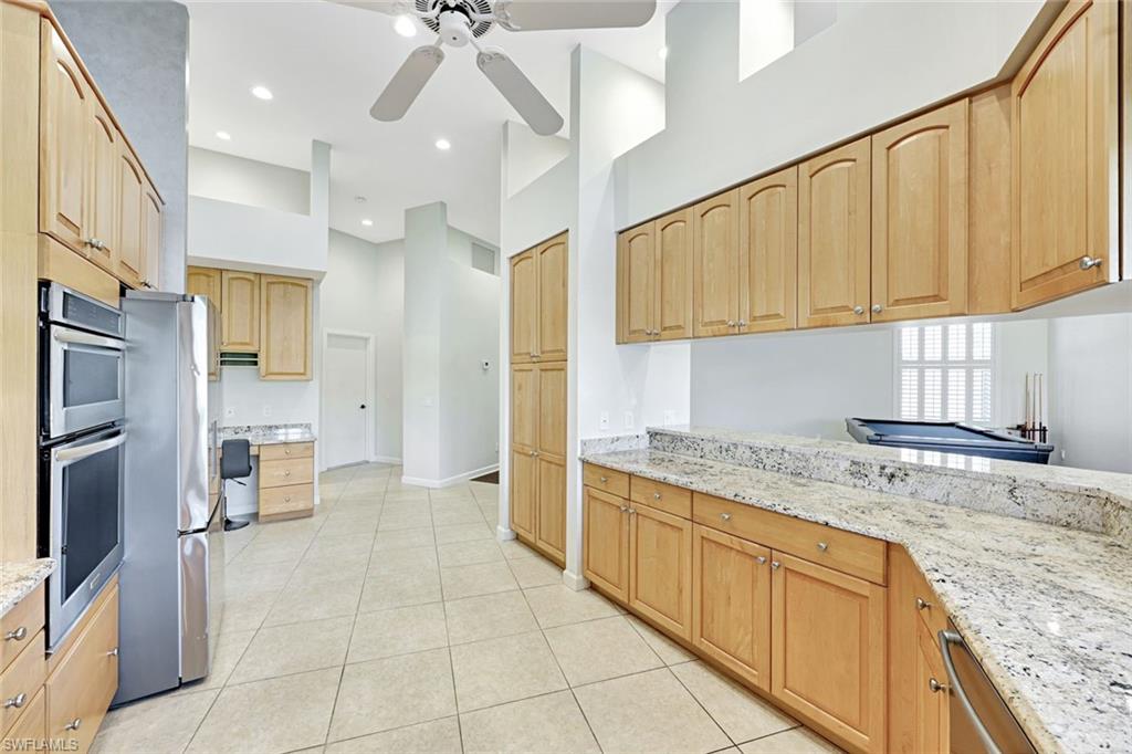 2035 Castle Garden Lane Naples, FL 34110 - Photo 16 of 40 a kitchen with a sink refrigerator and cabinets