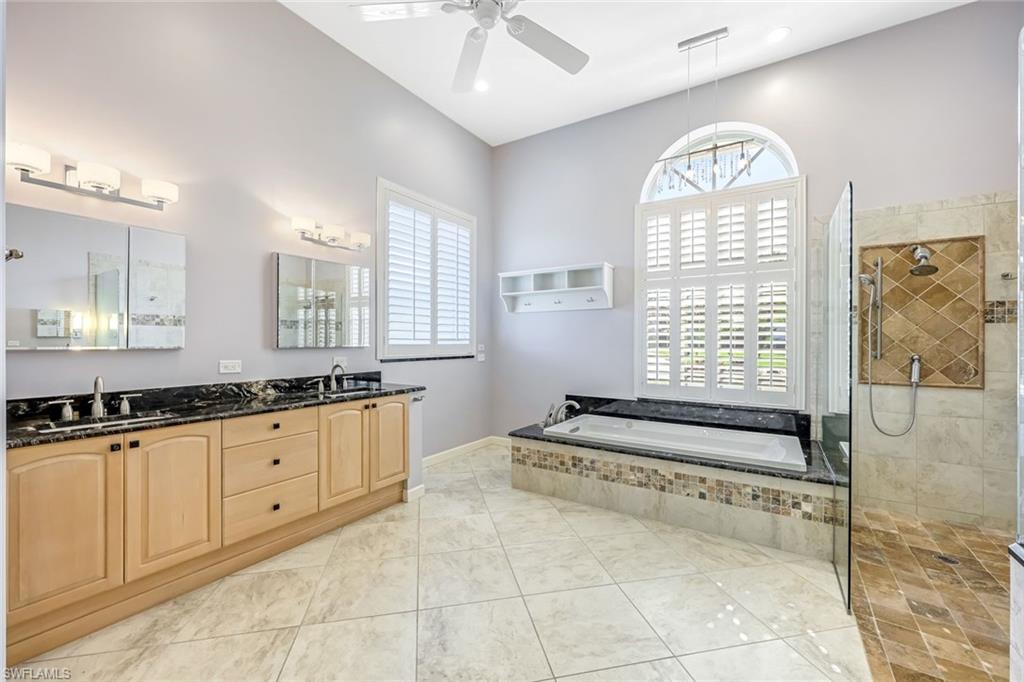 2035 Castle Garden Lane Naples, FL 34110 - Photo 20 of 40 a spacious bathroom with a granite countertop tub a sink and a large window