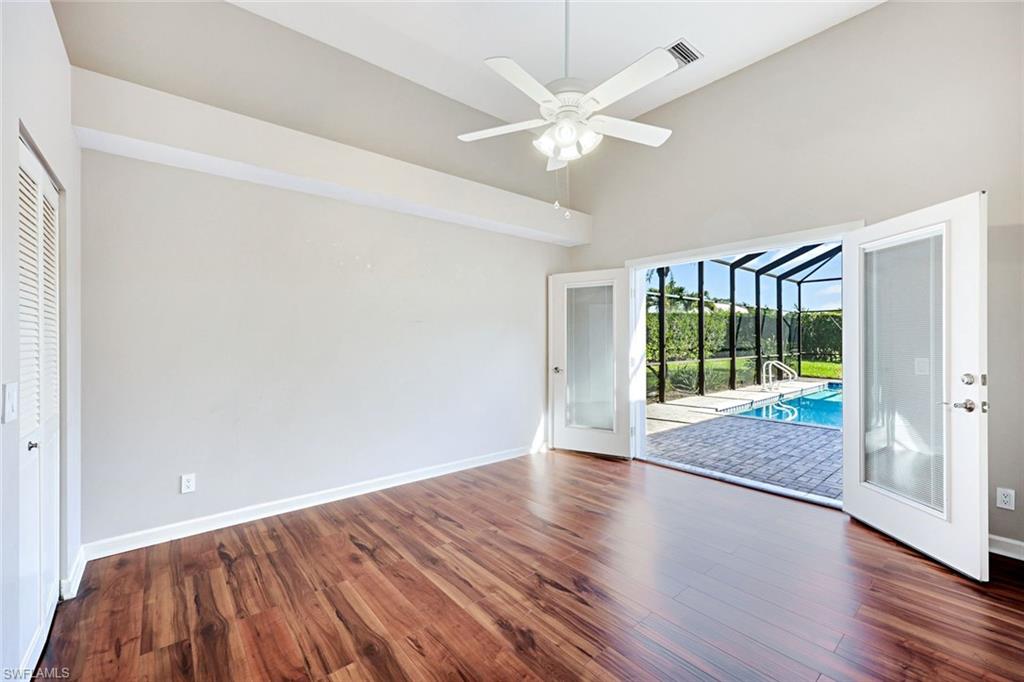 2035 Castle Garden Lane Naples, FL 34110 - Photo 22 of 40 a view of an empty room with wooden floor and a window
