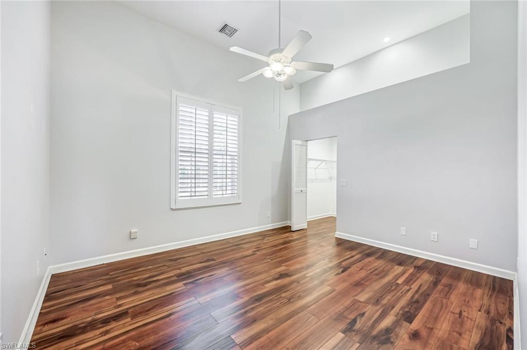 2035 Castle Garden Lane Naples, FL 34110 - Photo 24 of 40 a view of an empty room with wooden floor and a window