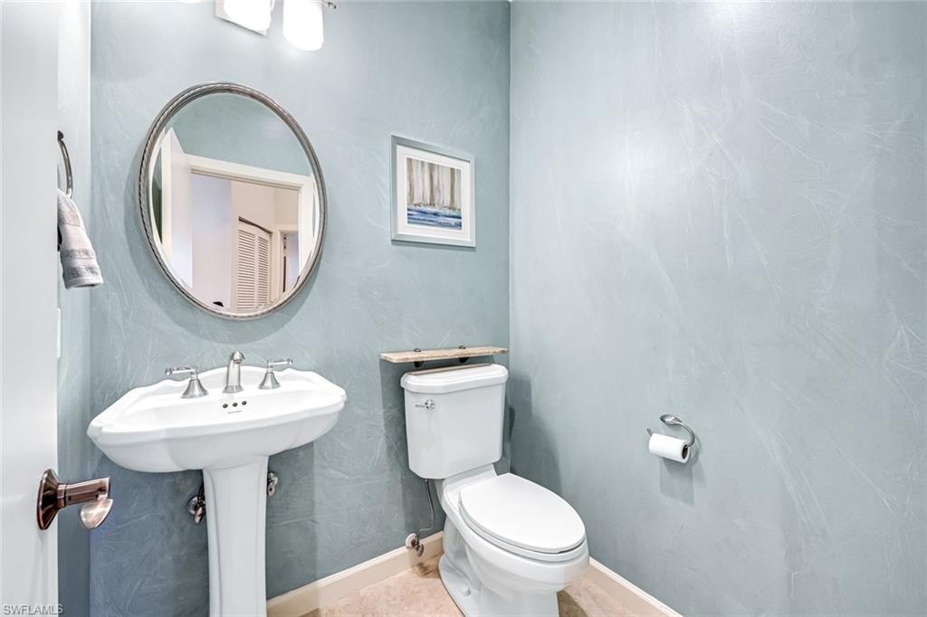 2035 Castle Garden Lane Naples, FL 34110 - Photo 25 of 40 a bathroom with a sink a mirror and a toilet