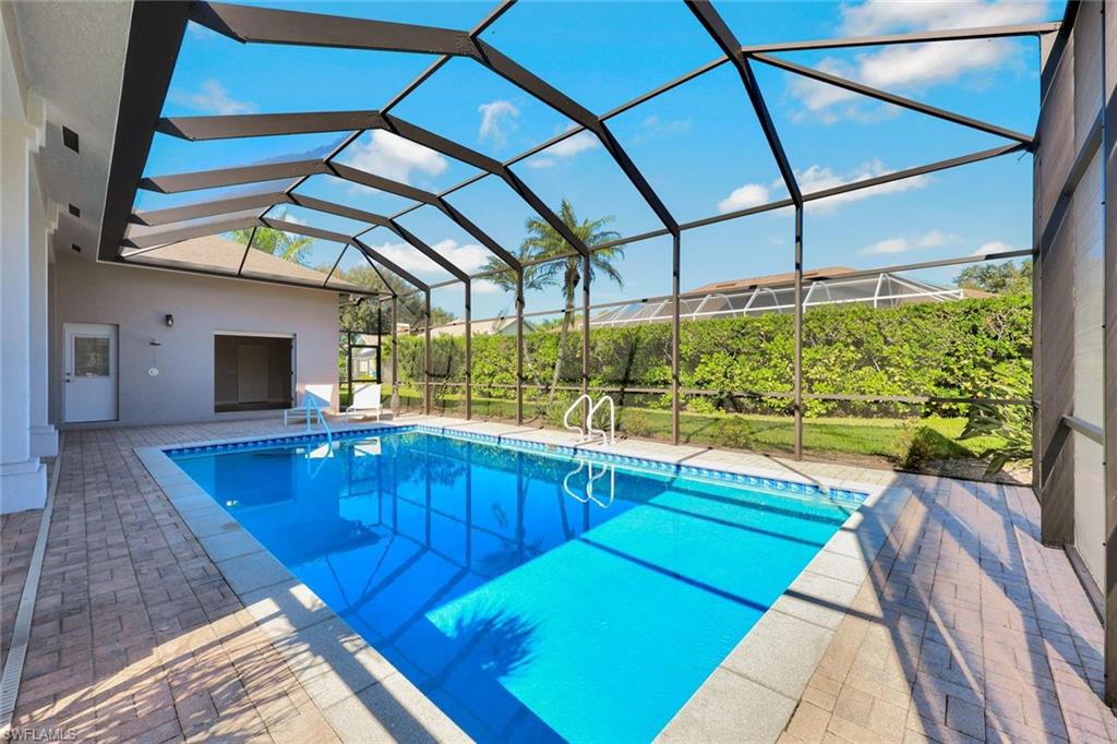 2035 Castle Garden Lane Naples, FL 34110 - Photo 31 of 40 a view of a backyard with table and chairs under an umbrella