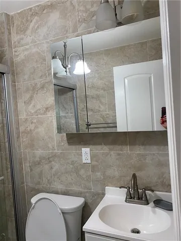 a bathroom with a sink a toilet and mirror