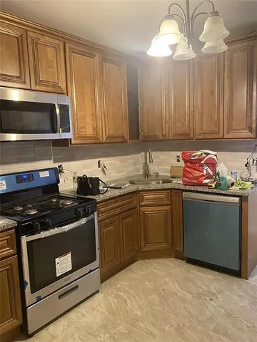 a kitchen with stainless steel appliances granite countertop a stove a sink and a microwave