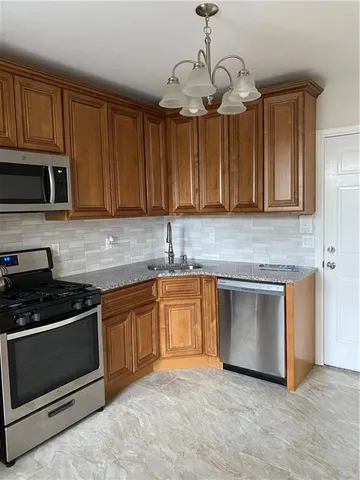 a kitchen with granite countertop stainless steel appliances a stove a sink cabinets and a microwave