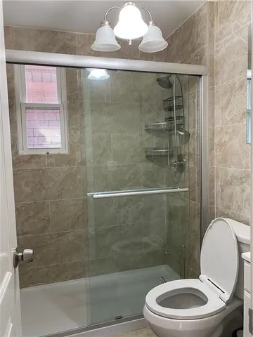 a bathroom with a toilet and a shower