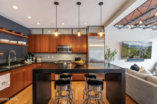a kitchen with stainless steel appliances granite countertop a sink a stove and a refrigerator