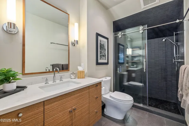 a bathroom with a sink toilet a mirror and shower