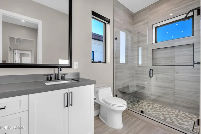 a bathroom with a sink a toilet and shower