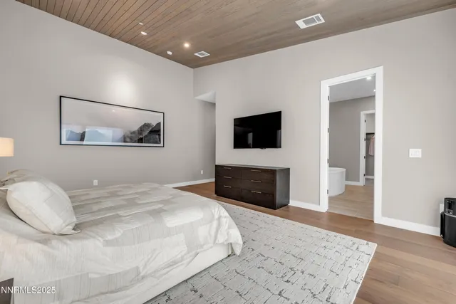 a bedroom with a bed and a flat screen tv