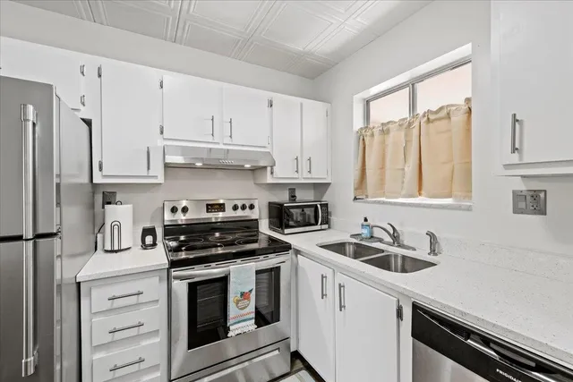 a kitchen with stainless steel appliances granite countertop a sink stove and cabinets