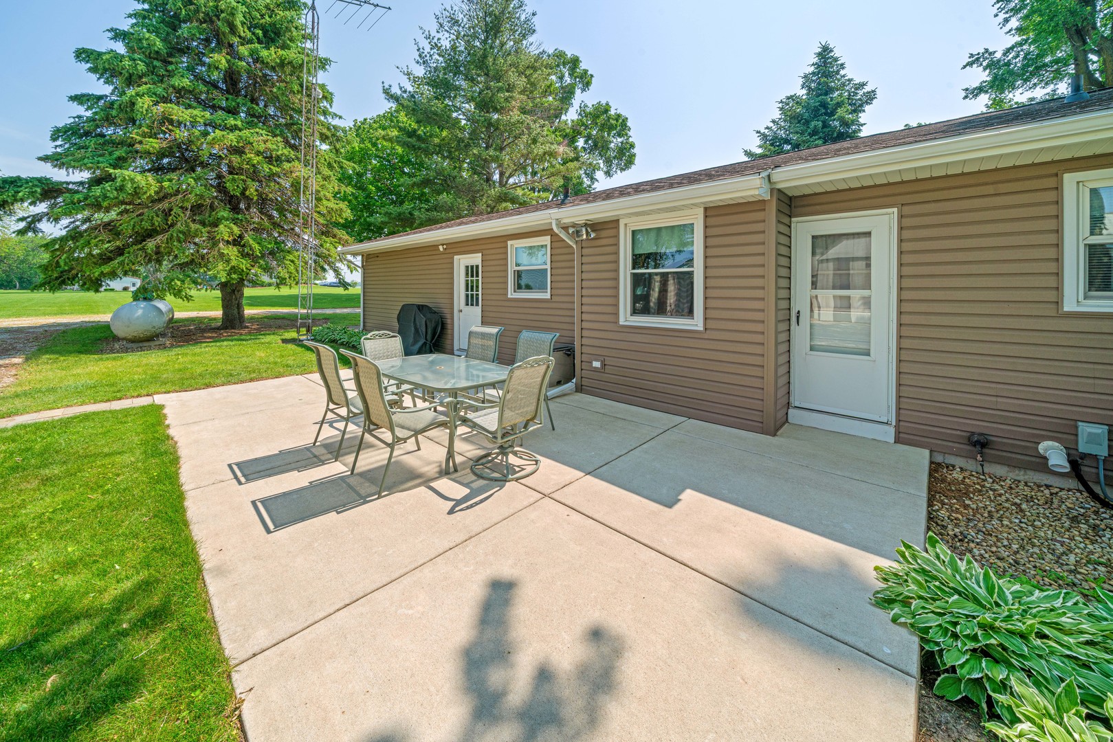 14893 Plank Road Sycamore, IL 60178 - Photo 5 of 33 a view of a patio with table and chairs with wooden fence and large trees