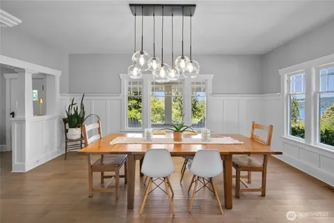 a dining room with furniture a chandelier and wooden floor