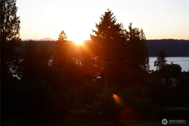 an aerial view of residential house with outdoor space and trees all around