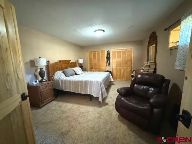 a bedroom with bed couch and window