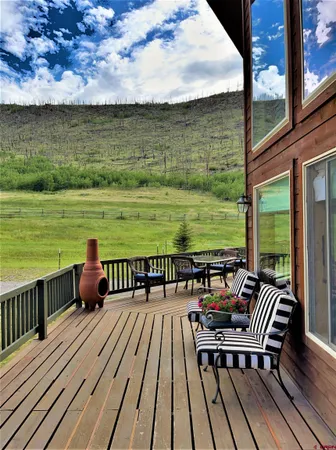 a view of a balcony with wooden floor and outdoor seating
