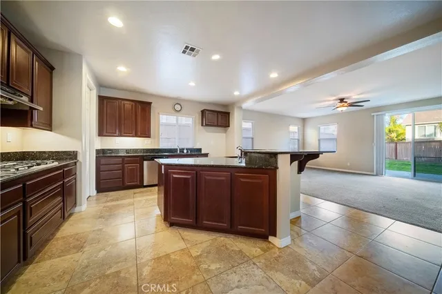 a large kitchen with stainless steel appliances granite countertop a large counter top and view of kitchen