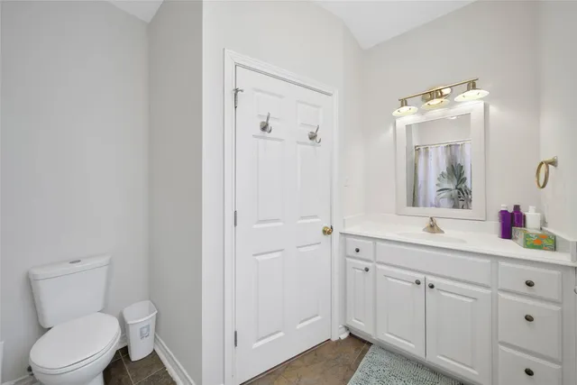 a bathroom with a granite countertop sink a toilet and a mirror