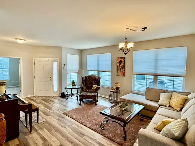 a living room with furniture and a chandelier