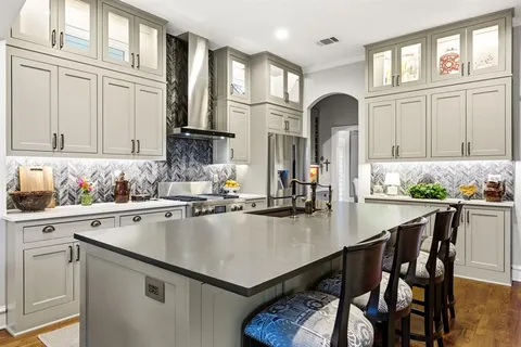a kitchen with stainless steel appliances granite countertop a table chairs and white cabinets