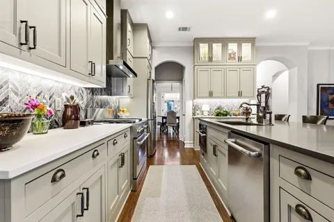a kitchen with stainless steel appliances granite countertop a lot of counter space and wooden floors
