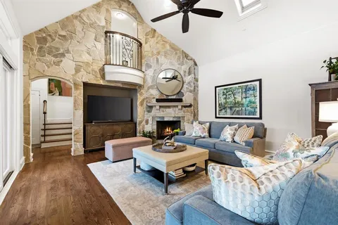 a living room with furniture a fireplace and a ceiling fan
