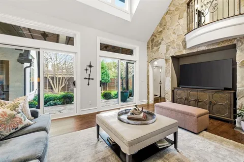 a living room with furniture floor to ceiling window and a flat screen tv
