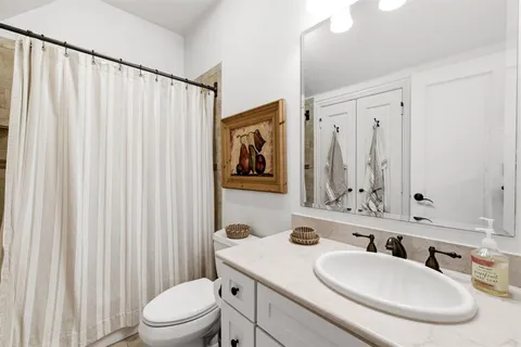 a bathroom with a toilet a sink and a mirror