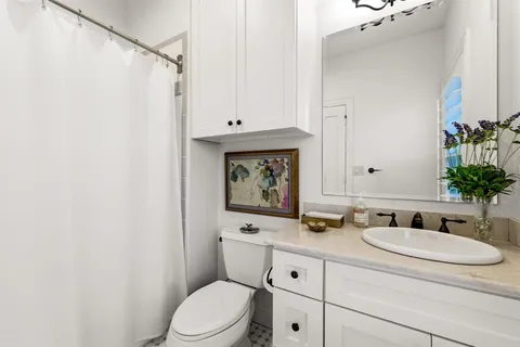a bathroom with a granite countertop sink mirror vanity and toilet