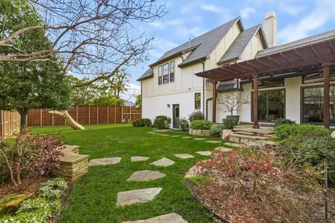 a view of a house with backyard and a tree