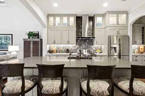 a kitchen with stainless steel appliances kitchen island granite countertop a dining table and chairs