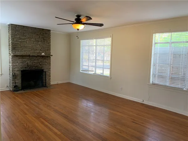 a view of an empty room with a fireplace and a window