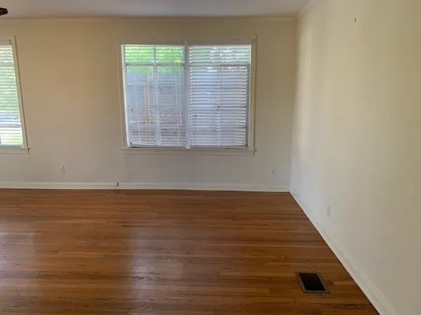a view of a room with wooden floor and window
