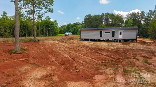 a view of a house with a yard and tree