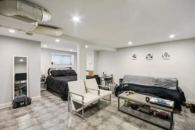 a living room with furniture a flat screen tv and a gym equipment