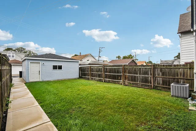a view of a backyard with plants and wooden fence