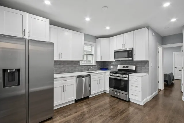 a kitchen with stainless steel appliances granite countertop a stove a refrigerator and a microwave